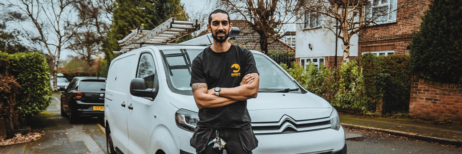 heating engineer in rhino tshirt standing in front of van